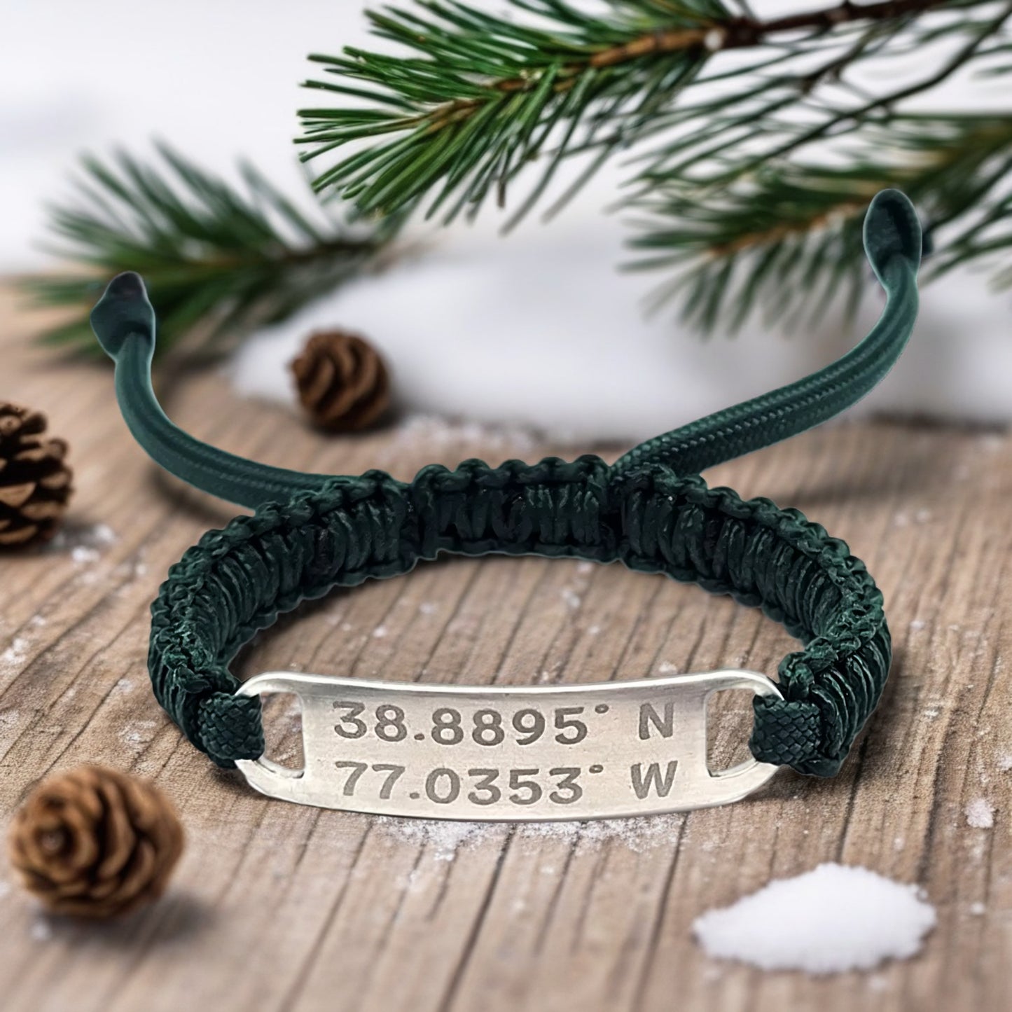 A close-up of the paracord bracelet on a wooden surface decorated with pinecones and faux snow, creating a rustic winter theme.