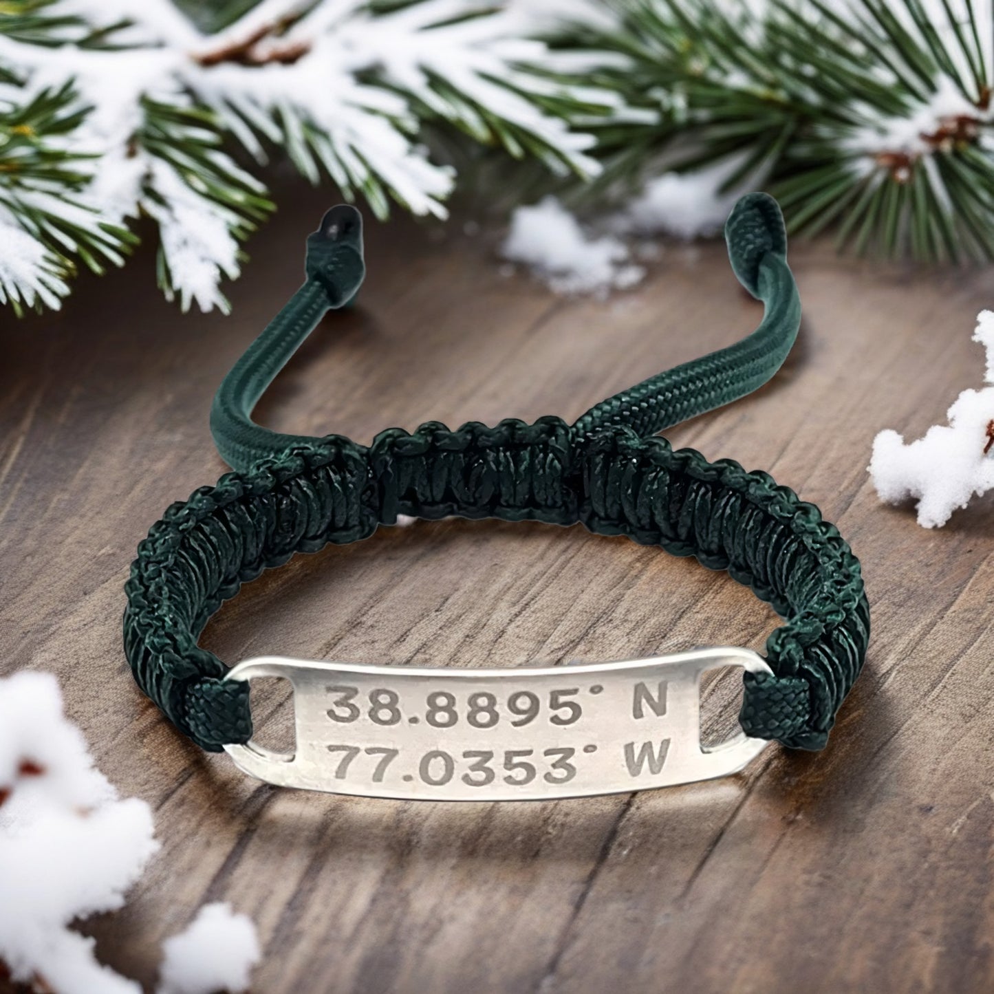 Dark green bracelet on a wooden table with snowy pine branches, showcasing the engraved tag in a festive setting.