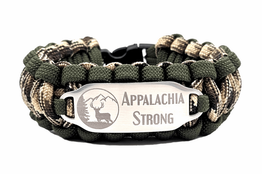 Camouflage paracord ID bracelet with a silver, stainless steel ID tag engraved with Appalachia Strong and a deer silhouette, displayed on an all white background.
