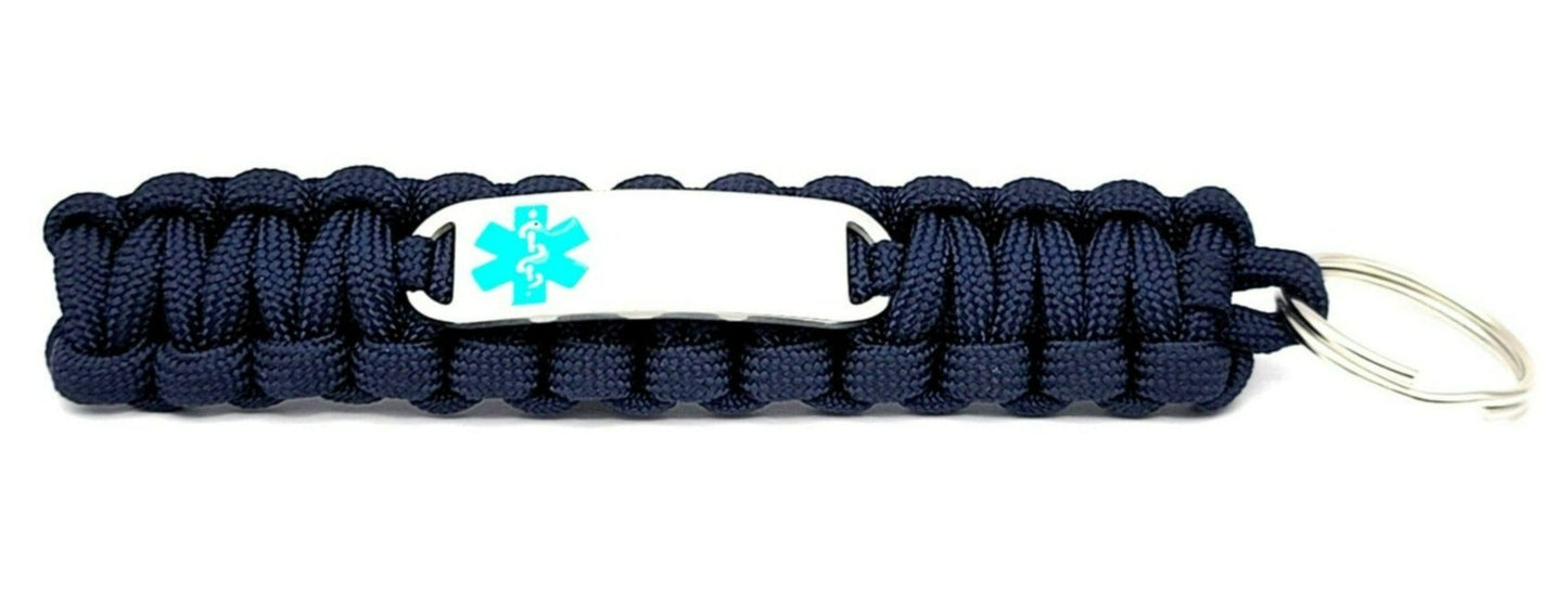 Navy paracord medical ID keychain with a silver, stainless steel ID tag with a teal enameled medical symbol, displayed on a white background.