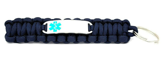 Navy paracord medical ID keychain with a silver, stainless steel ID tag with a teal enameled medical symbol, displayed on a white background.