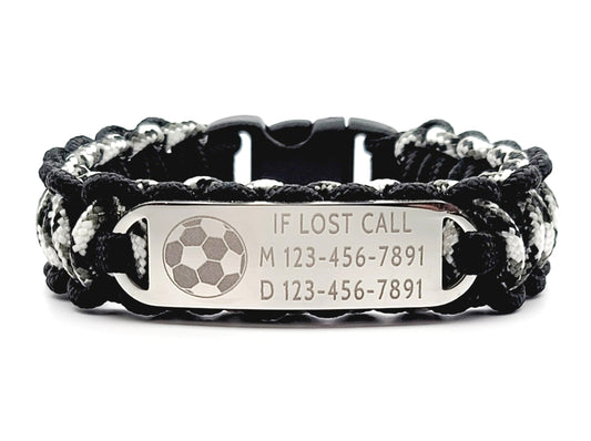 Black, white, & grey thin 275 paracord ID bracelet with a silver, stainless steel ID tag engraved with emergency contact information and a soccer symbol, displayed on a white background.