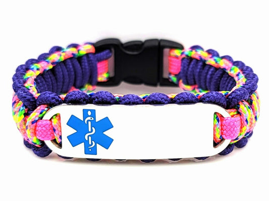 Pink and purple, colorful, thin, 275 paracord medical alert bracelet with a silver colored, stainless steel ID tag with an enameled blue medical symbol, displayed on a white background.