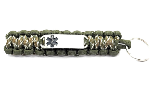 Green and camo paracord medical ID keychain with a silver, stainless steel ID tag with a black enameled medical symbol, displayed on a white background.