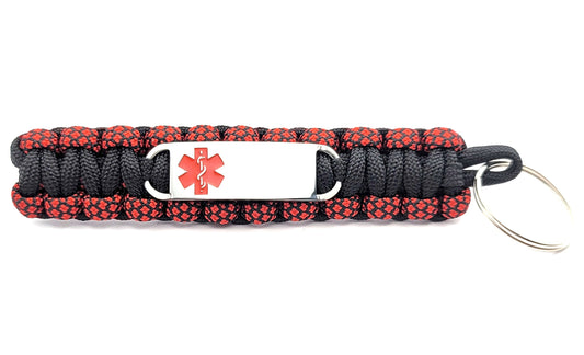 Black and red paracord medical ID keychain with a silver, stainless steel ID tag with a red enameled medical symbol, displayed on a white background.